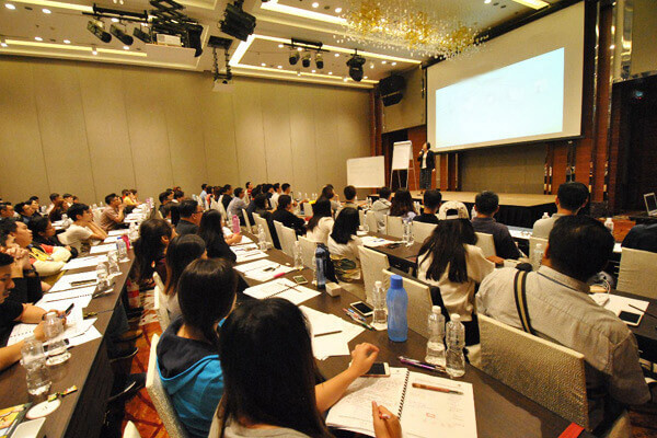 Students taking notes at long tables during a class