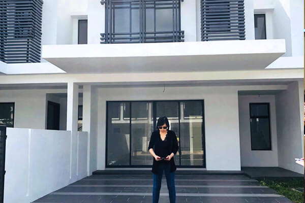 Master Suyen Lim taking a reading in front of a newly built house