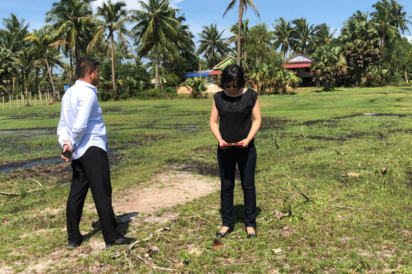 Master Suyen Lim reading the ground of an open plot beside a client